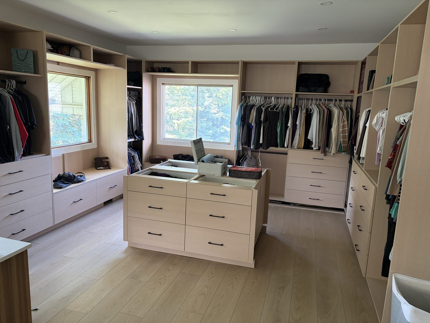 Full dressing room with centre island, window seat and white oak finish
